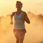 A focused runner in their 20s strides through a suspended protein powder veil at sunset, symbolizing breakthrough moments in nutrition awareness.